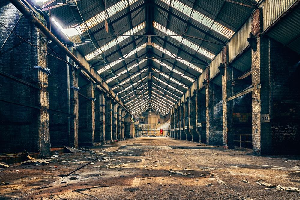 Lost-Place-Fototapete mit einer alten Fabrikhalle